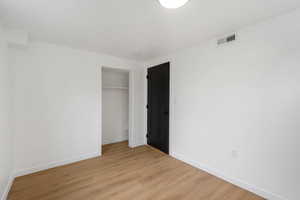 Unfurnished bedroom with light wood-type flooring and a closet