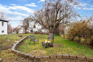 View of green lawn with an outdoor fire pit