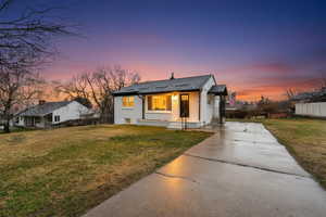 Bungalow-style house with a front yard, driveway, and brick siding