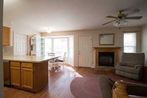Kitchen with a peninsula, dark floors, light counter tops, open floor plan, and dishwasher