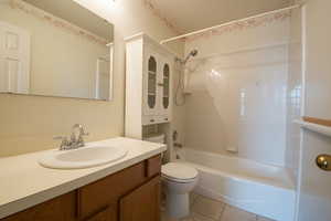 Full bathroom with vanity, shower / bath combination, and light tile patterned floors