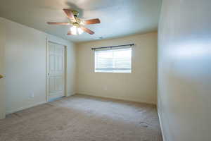 Bedroom 1 in the basement featuring a textured ceiling, light colored carpet, and ceiling fan, and primary Bathroom.