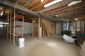 Unfinished below grade area with stairway and water heater, Storage, washer and dryer hookups and furnace.