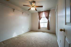 Bedroom 2 with ceiling fan and carpet floors, and closet