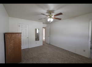 Primary bedroom featuring carpet floors and ceiling fan