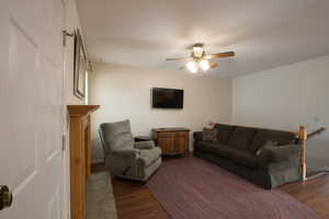 Living room featuring wood finished floors and ceiling fan right off the kitchen