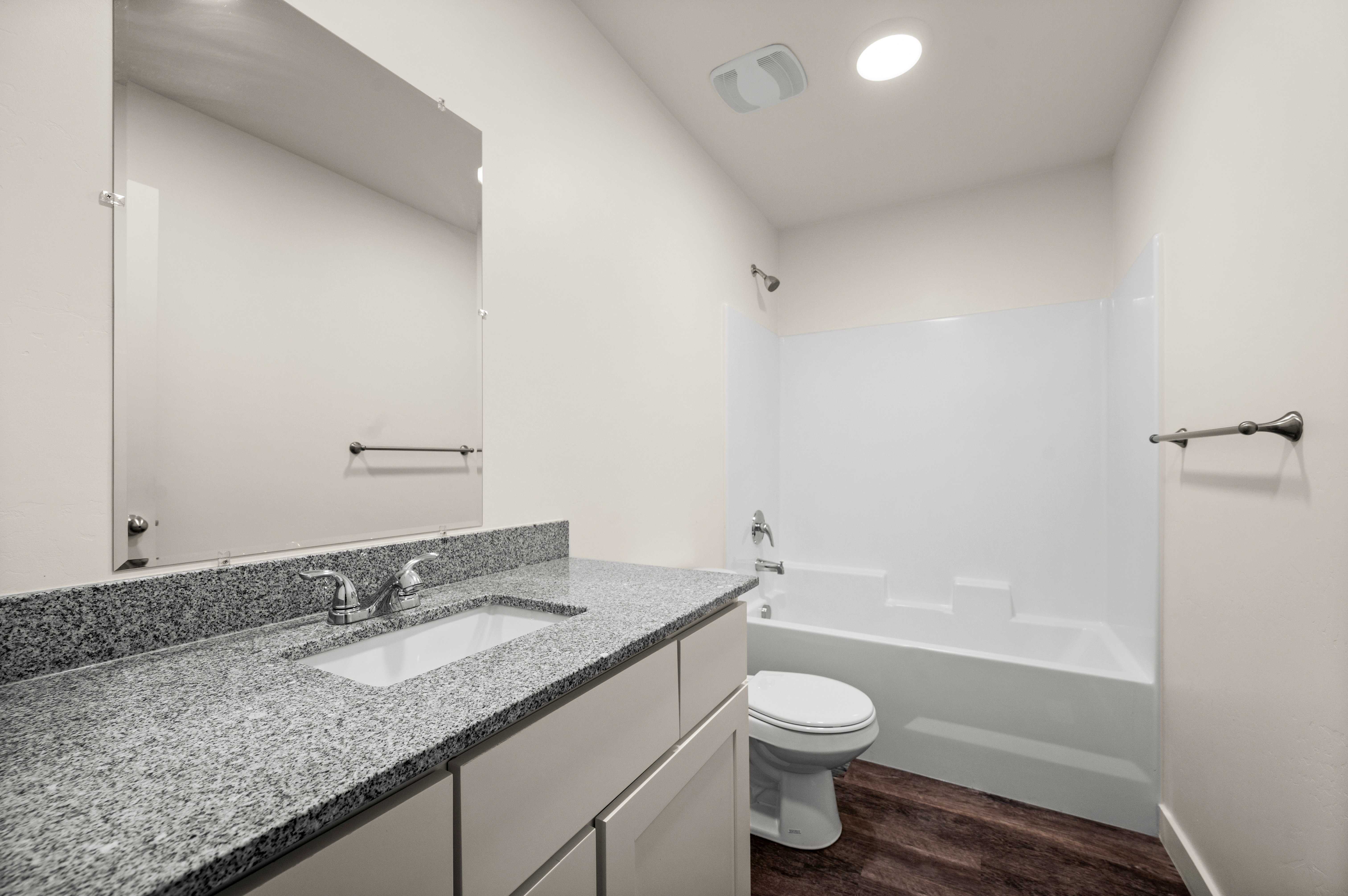 Bathroom featuring a full vanity with an integrated sink, granite-style countertop, and ample storage cabinetry