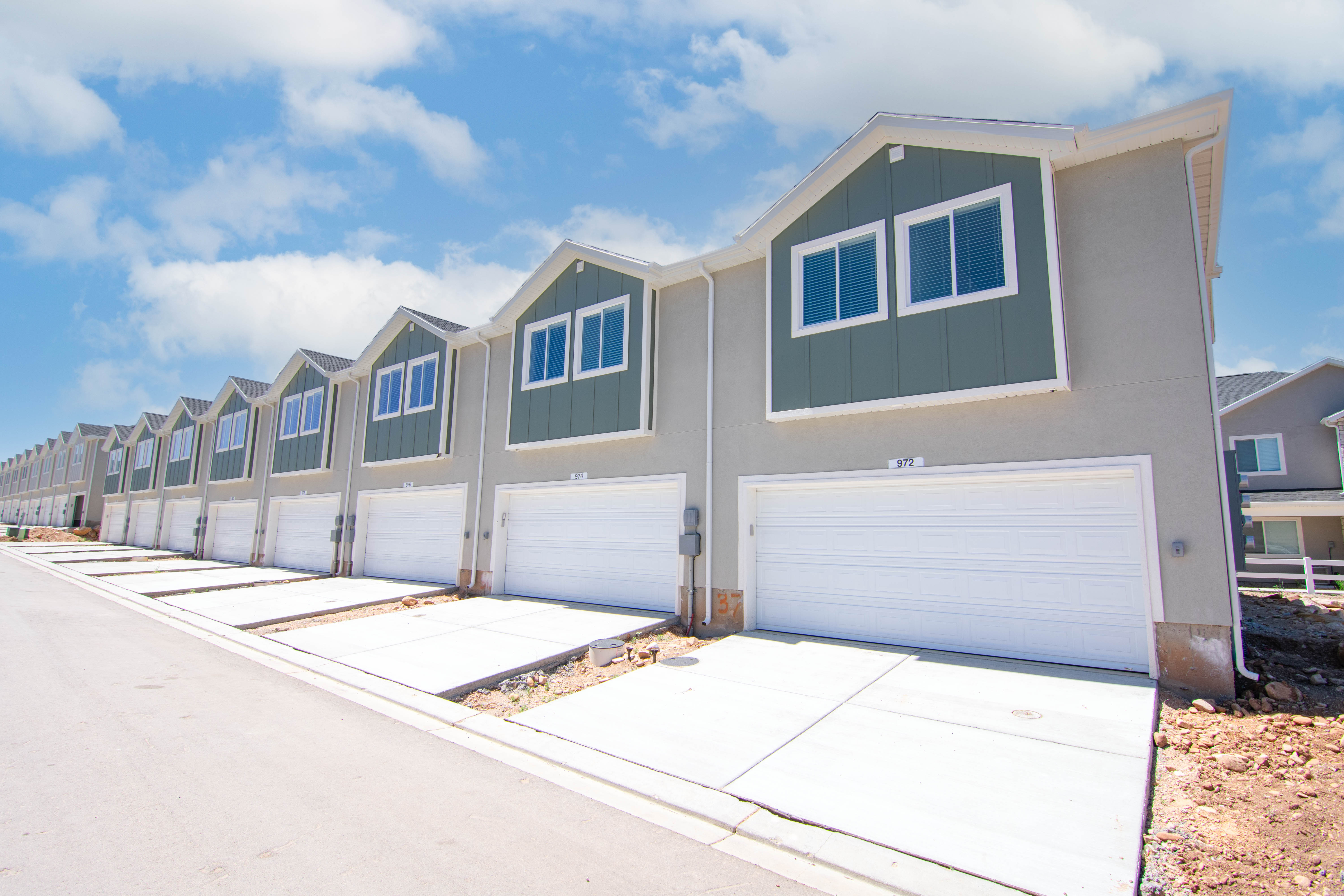 View of front of home with board and batten siding, a residential view, driveway, and an attached garage