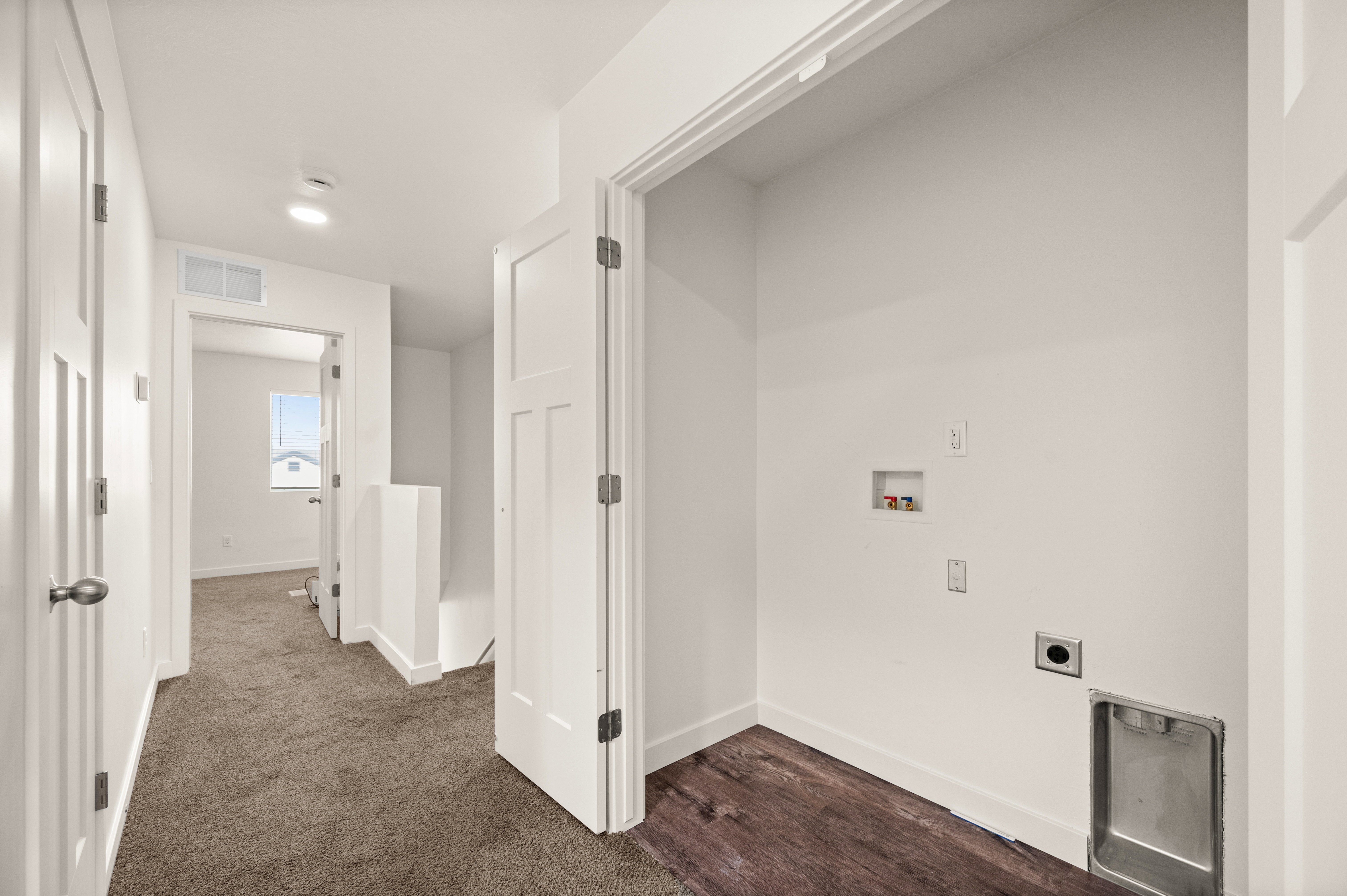 Dedicated laundry area featuring wood-finish flooring, utility hookups, and a utility sink