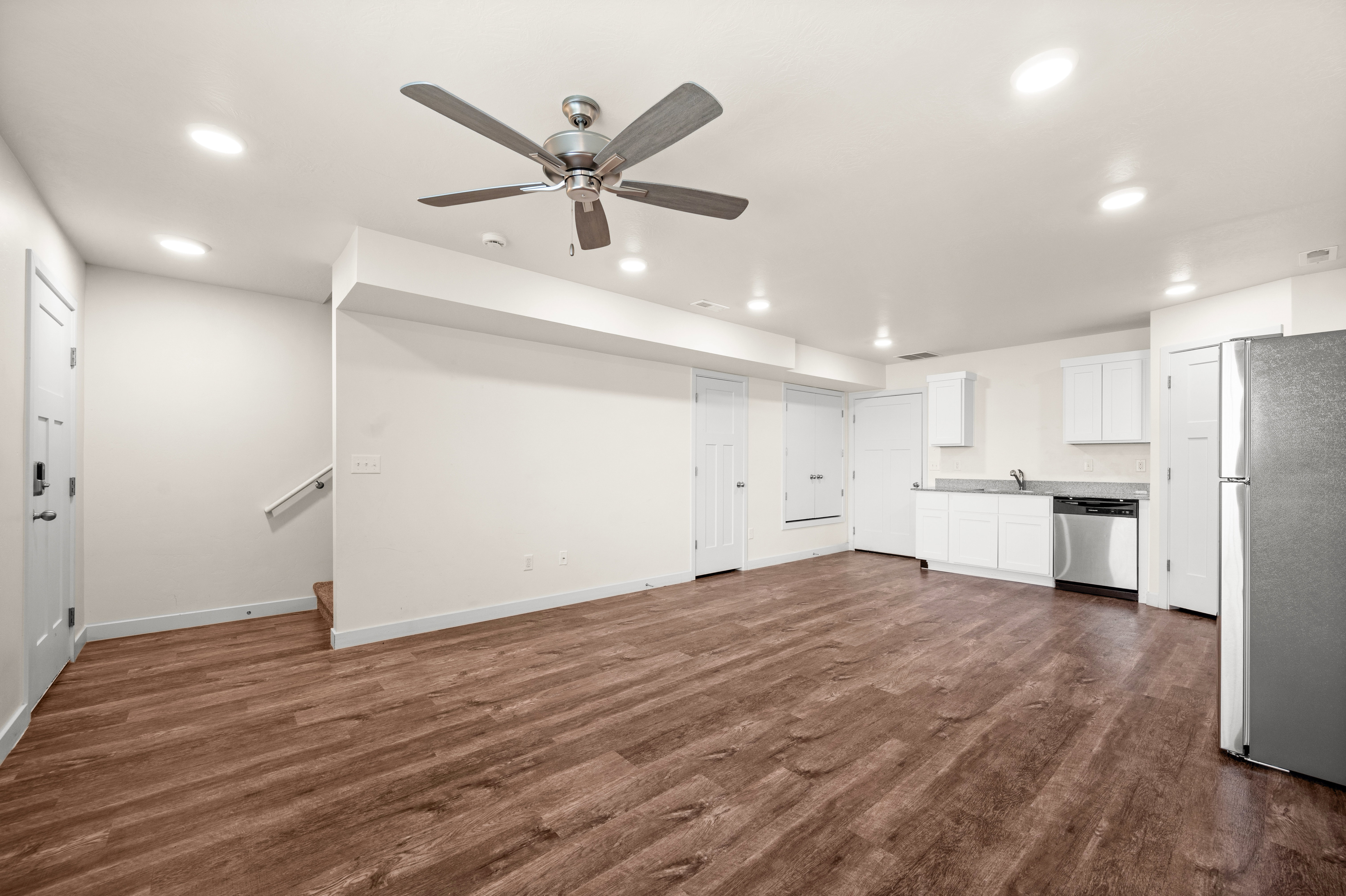 Open-concept living space featuring wood-finish flooring, recessed lighting, and a ceiling fan