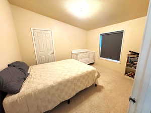 Bedroom featuring light carpet and vaulted ceiling