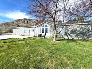 View of front facade featuring a front yard, board and batten siding, a patio, and a mountain view