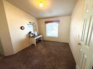 Office featuring dark carpet and a textured wall