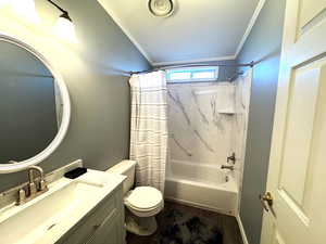 Bathroom featuring crown molding, vanity, shower / bath combination with curtain, and dark wood-style flooring
