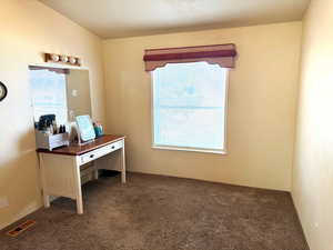 Office space featuring dark colored carpet and healthy amount of natural light