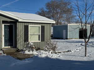 View of snowy exterior featuring an outdoor structure