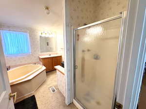 Full bath featuring wallpapered walls, vanity, a garden tub, and a shower stall