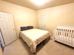 Bedroom featuring light colored carpet