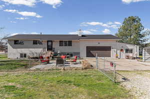 View of front of home featuring driveway, a chimney, an attached garage, a fenced front yard, and a gate