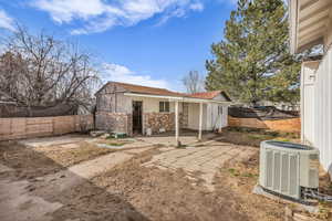 Back of property with a fenced backyard, brick siding, and a shingled roof