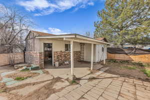 Back of property with brick siding and a fenced backyard