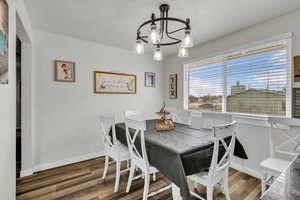 Dining space featuring dark wood finished floors and hanging lights