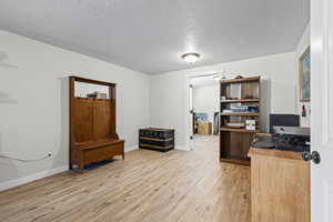 Office featuring light wood finished floors and a textured ceiling