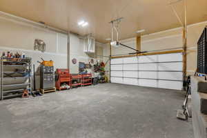 Garage featuring freestanding refrigerator and a garage door opener