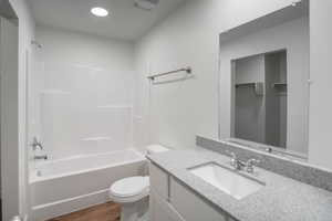 Full bathroom featuring vanity, bathing tub / shower combination, and dark wood-style floors