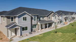 View of front of home featuring board and batten siding, a shingled roof, a front lawn, a residential view, and a porch