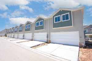 View of front of home with board and batten siding, a residential view, driveway, and an attached garage