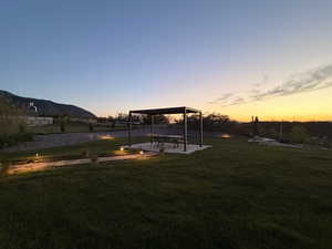 Yard at dusk with a patio and a lawn