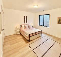 Bedroom with light wood-type flooring and a textured ceiling