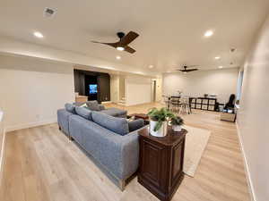 Living area with light wood finished floors, a ceiling fan, and recessed lighting