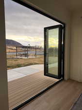 Doorway to outside with a water and mountain view and wood finished floors