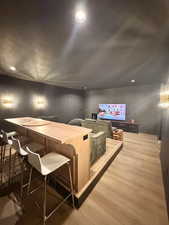 Home theater with light wood finished floors and recessed lighting