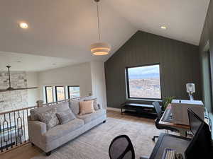 Living room with light wood-style flooring, a desk, wooden walls, plenty of natural light, and recessed lighting
