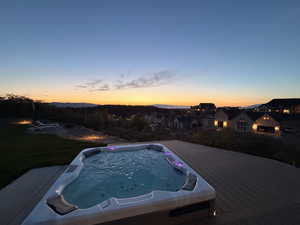 Pool at dusk featuring a wooden deck and a residential view