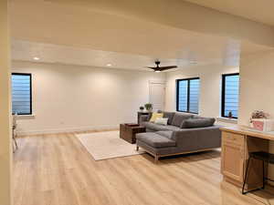 Living area featuring light wood finished floors, a ceiling fan, and recessed lighting