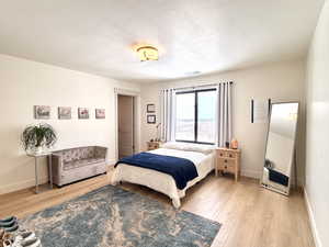 Bedroom featuring light wood-type flooring and a textured ceiling