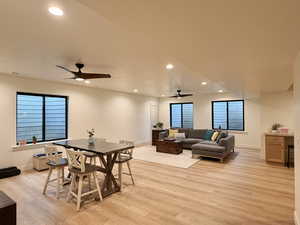 Dining area featuring light wood finished floors, a ceiling fan, recessed lighting, and plenty of natural light