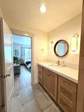 Bathroom featuring vanity, ensuite bathroom, and dark tile patterned flooring