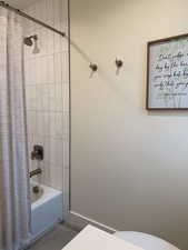 Full bath featuring shower / bath combo with shower curtain and toilet