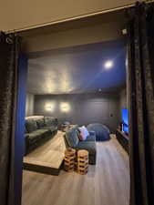 Home theater featuring light wood finished floors and a textured wall