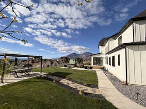 View of grassy yard with a patio area and a mountain view