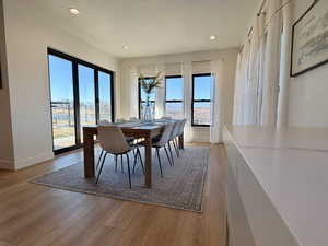 Dining space with light wood-type flooring and recessed lighting