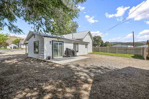 Rear view of property featuring a patio area, a metal roof, and a fenced backyard