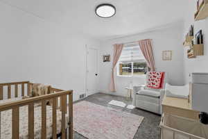 Bedroom featuring a crib and baseboards