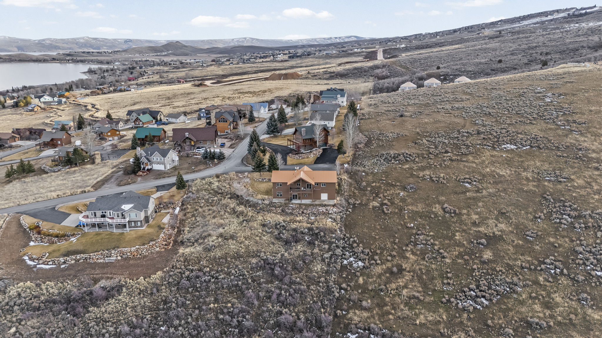 Aerial view of property's location with nearby suburban area and a mountainous background