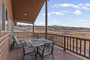 Wooden terrace featuring outdoor dining space and a mountain view
